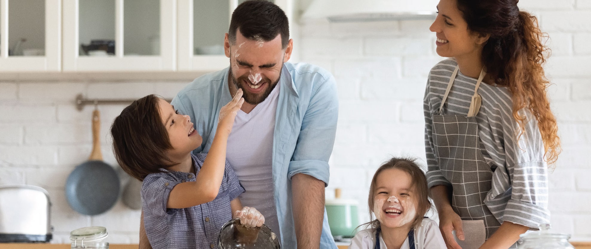 Family baking together in kitchen and laughing